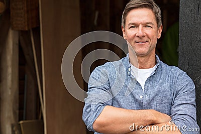 Happy Middle Aged Man Arms Folded by His Garage Stock Photo