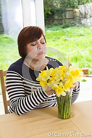 Happy middle aged woman with yellow bouquet Stock Photo