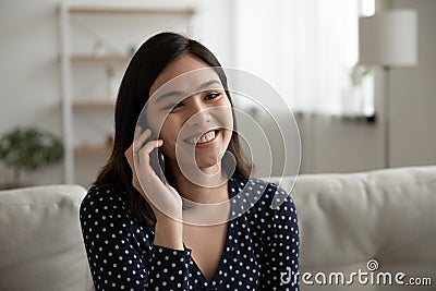 Happy millennial asian female enjoy chat by cell with friend Stock Photo