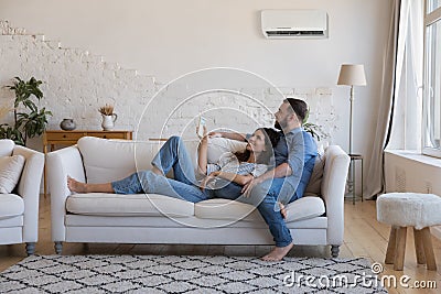 Happy millennial couple of homeowners enjoying cool conditioned air Stock Photo