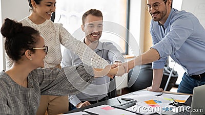 Happy millennial diverse multiracial business people bumping fists. Stock Photo