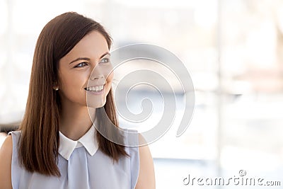 Happy millennial female employee look in distance dreaming Stock Photo