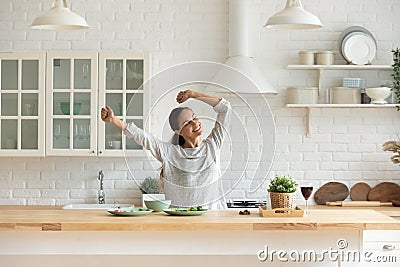 Happy millennial woman have fun cooking breakfast in kitchen Stock Photo