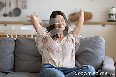 Happy millennial girl relax on comfortable sofa at home Stock Photo