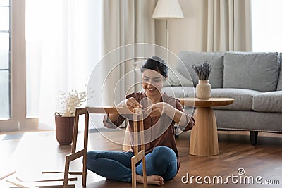 Smiling Indian woman gather piece of furniture Stock Photo