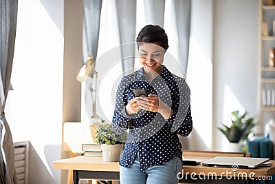 Happy indian girl using cellphone texting or messaging Stock Photo