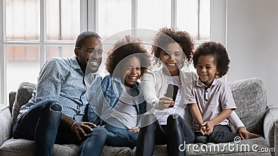 Happy millennial parents and children using smartphone Stock Photo