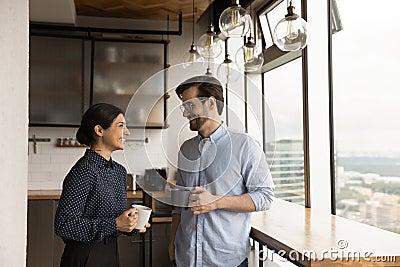 Happy mixed race couple drink tea coffee by picture window Stock Photo