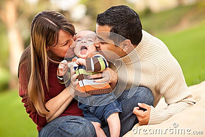Happy Mixed Race Parents Playing with Their Son Stock Photo