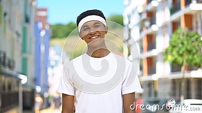 Happy mixed-race teen athlete with headband smiling on cam, wellness and health Stock Photo