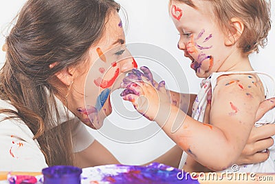 Happy mom and baby playing with painted face by paint Stock Photo