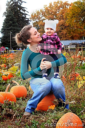 Happy Mom and Baby in pumpkin patch Stock Photo