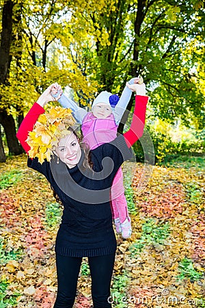 Happy mom and child girl hugging on nature at fall. The concept of childhood and family. Stock Photo