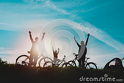 Happy mom, dad with kids biking at sunset nature, family enjoy riding bikes Stock Photo