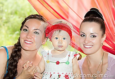 Happy mom, godmother and baby girl hugging and laughing. Stock Photo