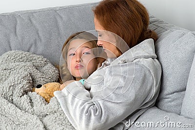 Mom sitting on couch with daughter Stock Photo