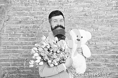 Happy moments. Love date. happy international holiday. happy bearded man with tulip bouquet and bear. Flower for March 8 Stock Photo