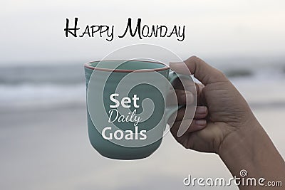 Happy Monday. Monday concept with business motivational text message on a coffee cup in hand - Set daily goals. Monday goal. Stock Photo