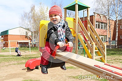 Happy 18 months baby on seesaw outdoors Stock Photo