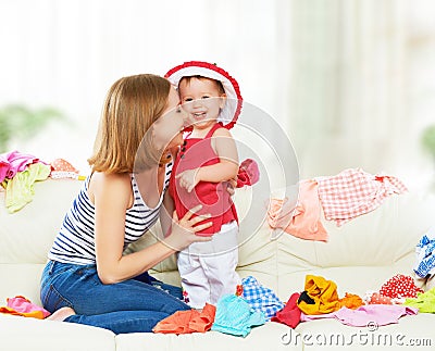 Happy Mother and baby girl with clothes ready for traveling on Stock Photo