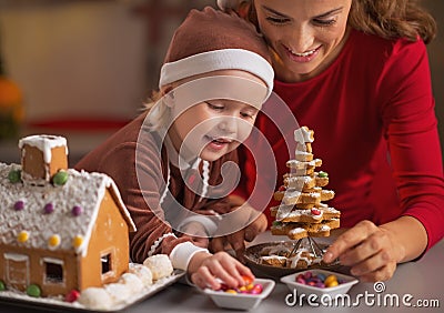 Happy mother and baby making christmas cookie house in kitchen Stock Photo