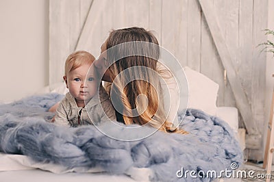 Happy mother and baby playing at home in bedroom. Cozy family lifestyle Stock Photo