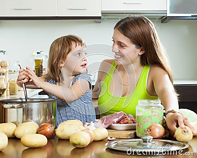 Happy mother with child cooking soup f Stock Photo