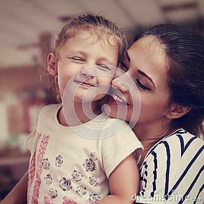Happy mother and cute enjoying girl cuddling with love indoor. C Stock Photo