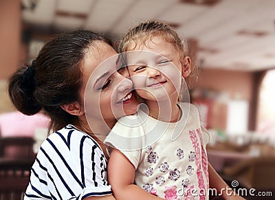 Happy mother and cute enjoying girl cuddling with love indoor Stock Photo