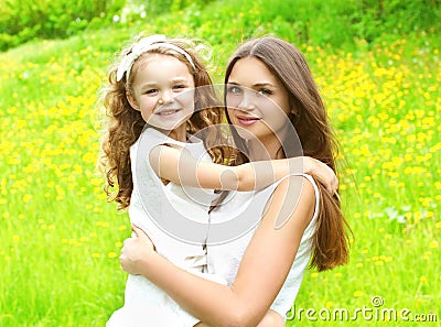 Happy mother and daughter child hugging in summer Stock Photo