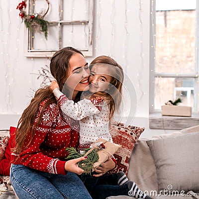 Happy mother and daughter embrace holding gifts. Stock Photo