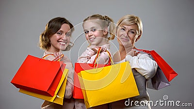 Happy mother, daughter and granny holding shopping bags, female leisure, sale Stock Photo