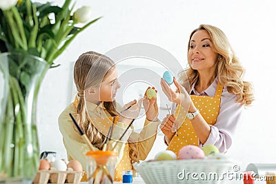 Happy mother and daughter holding paintbrushes Stock Photo