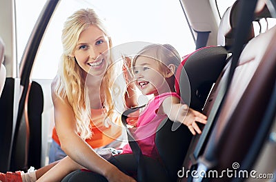 Happy mother fastening child with car seat belt Stock Photo