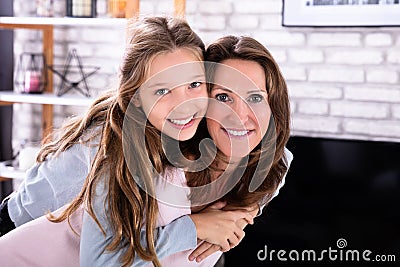 Happy Mother Giving Piggyback To Her Daughter Stock Photo