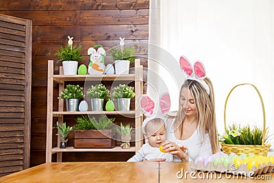 Happy mother and her cute child wearing bunny ears, getting ready for Easter Stock Photo