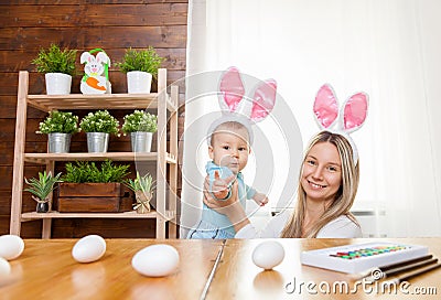 Happy mother and her cute child wearing bunny ears, getting ready for Easter Stock Photo