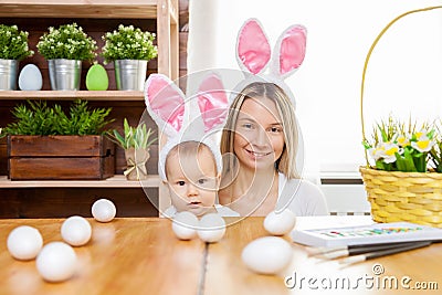 Happy mother and her cute child wearing bunny ears, getting ready for Easter Stock Photo