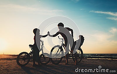 Happy mother with kids biking at sunset Stock Photo