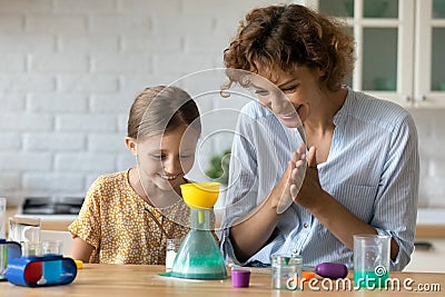 Happy mother and little daughter having fun with toy laboratory Stock Photo
