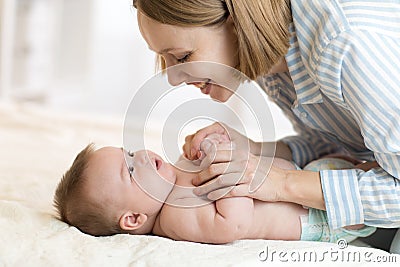 Happy mother looking at baby in bedroom Stock Photo