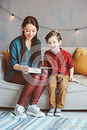 Happy mother reading book to child son at home Stock Photo