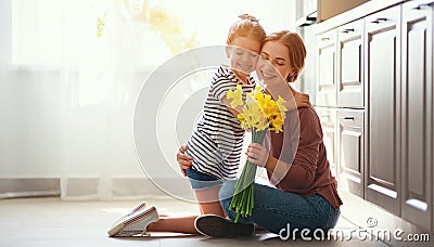 Happy mother`s day! child daughter gives mother a bouquet of flowers to narcissus and gift Stock Photo