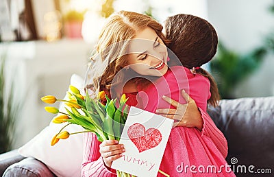 Happy mother`s day! child daughter gives mother a bouquet of flowers to tulips and postcard Stock Photo