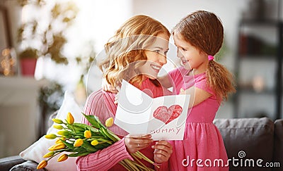 Happy mother`s day! child daughter gives mother a bouquet of flowers to tulips and postcard Stock Photo