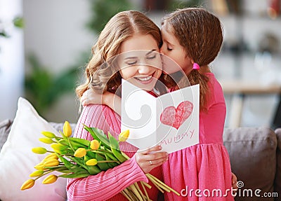 Happy mother`s day! child daughter gives mother a bouquet of flowers to tulips and postcard Stock Photo