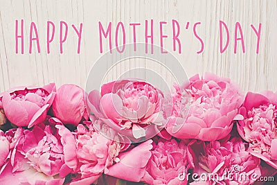 Happy mother`s day text on pink peonies bouquet on rustic white Stock Photo