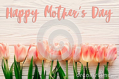 Happy mother`s day text sign on pink tulips on white rustic wood Stock Photo