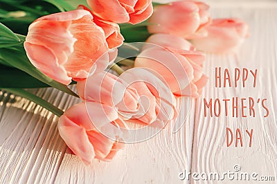 Happy mother`s day text sign on pink tulips on white rustic wood Stock Photo