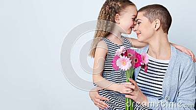 Happy Mother`s Day, Women`s day or Birthday background. Cute little girl giving mom bouquet of pink gerbera daisies. Loving mother Stock Photo